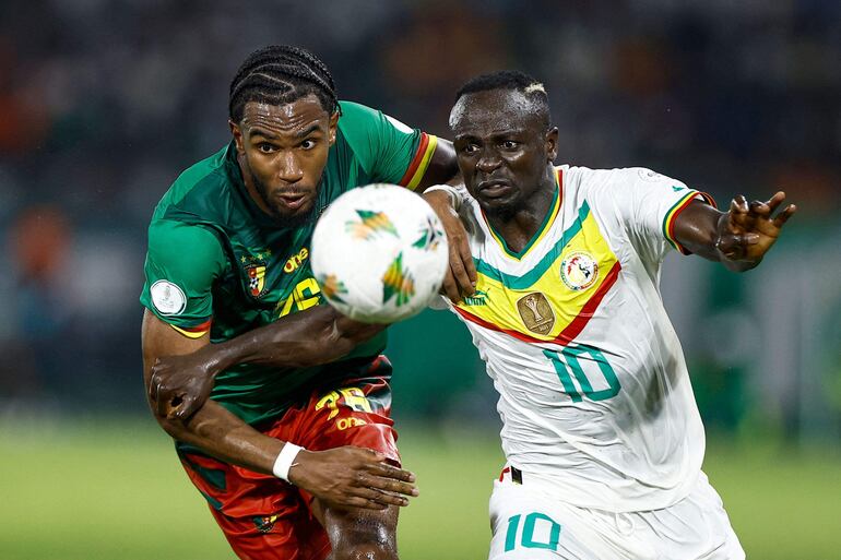 Sadio Mané (d) en férrea disputa por el balón con el camerunés Enzo Tchato, durante el partido que Senegal ganó ayer por 3-1.