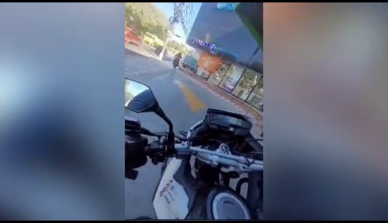 La motociclista escapando por la entrada de vehículos de un conocido supermercado.