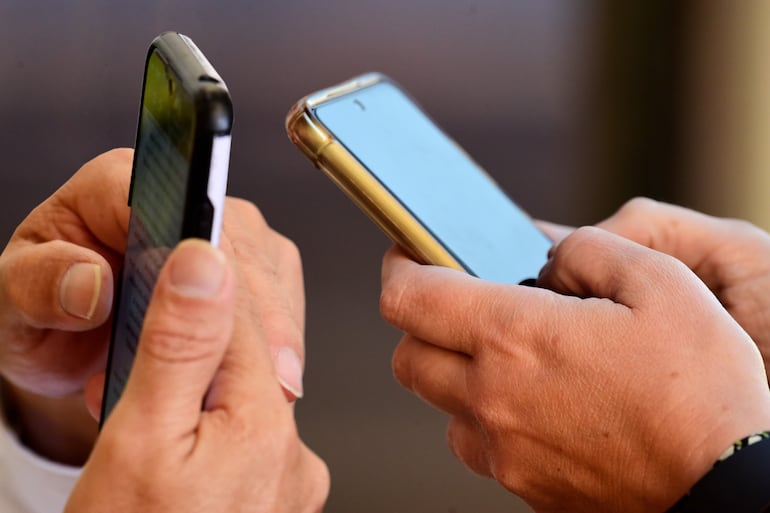 Personas revisando sus teléfonos celulares.