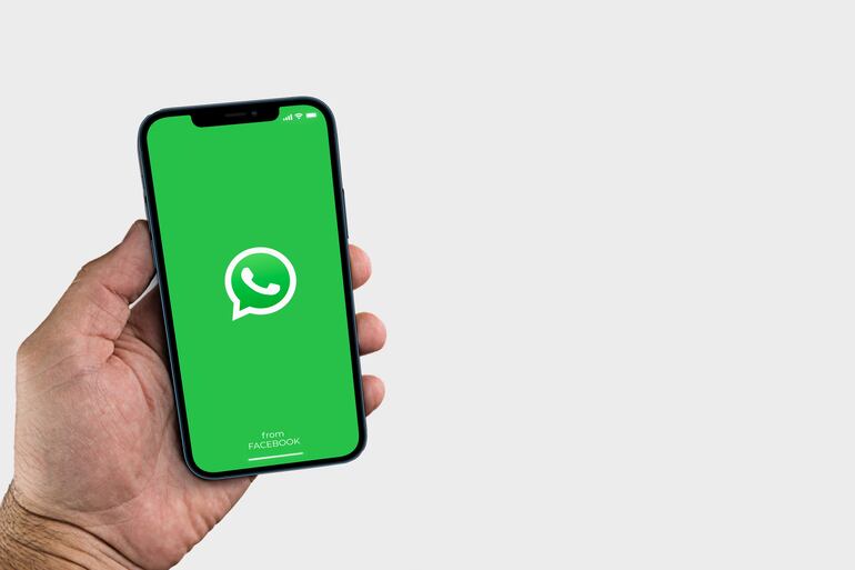 Un hombre sostiene un teléfono celular con la aplicación de whatsapp activada