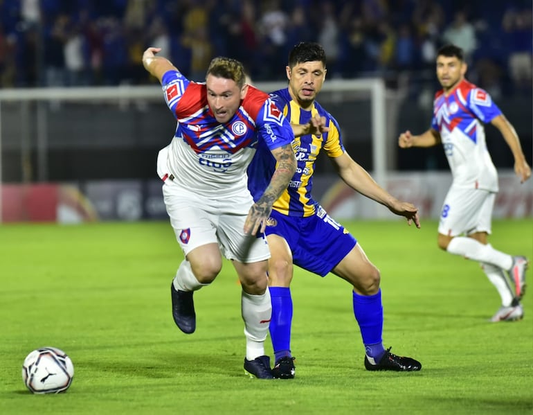 Fernando Fernández, de Cerro Porteño, disputa el balón con Rodrigo Rojas, del Sportivo Luqueño, en el Defensores del Chaco.