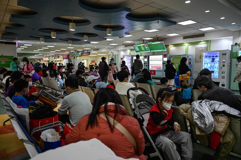 Niños y sus padres esperan en un área ambulatoria de un hospital infantil en Beijing.