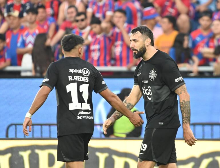 El argentino Lucas Pratto (d) y Rodney Redes, jugadores de Olimpia festejan un gol en el superclásico ante Cerro Porteño por la sexta fecha del torneo Clausura 2024 del fútbol paraguayo en el estadio La Nueva Olla, en Asunción.