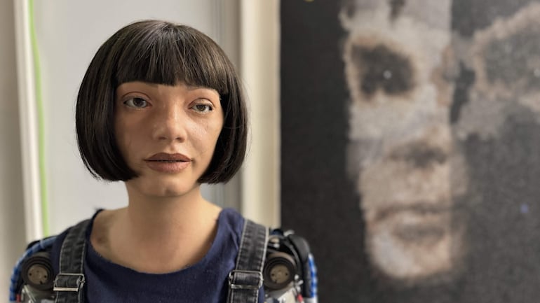 Geneva (Switzerland), 01/11/2024.- An undated handout photo made available by Sotheby's on 01 November 2024 shows the Ai-Da Robot in front of their AI created 'A.I. God. Portrait of Alan Turing' artwork, at the United Nations in Geneva, Switzerland. Ai-Da Robot is the first humanoid robot artist to have an artwork auctioned by a major auction house, participating in Sotheby's Digital Art Sale from 31 October to 07 November. (Suiza, Ginebra) EFE/EPA/SOTHEBY'S HANDOUT MANDATORY CREDITHANDOUT EDITORIAL USE ONLY/NO SALES
