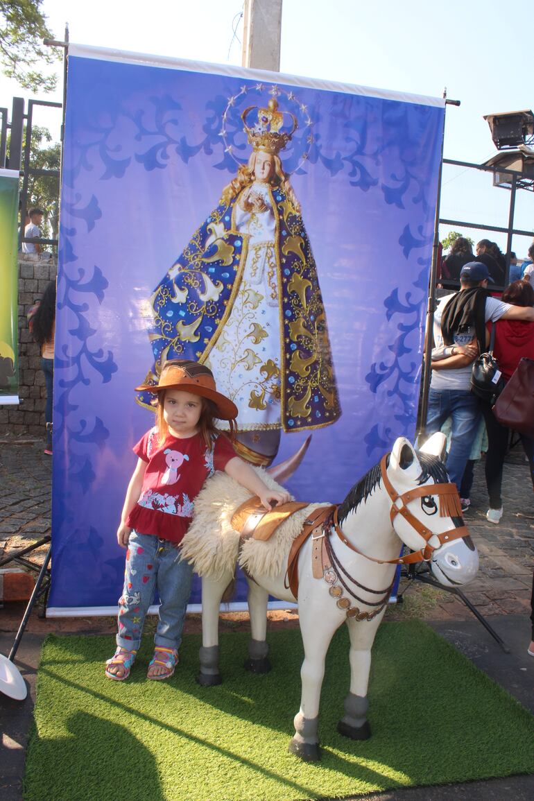 Los padres toman fotografías a su hijos en el tradicional caballito de Caacupé.