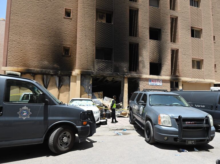 Un policía fuera del edificio siniestrado este miércoles en la zona de Mangaf, Kuwait.