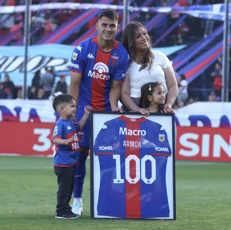 Blas Armoa posa con su familia junto al reconocimiento que le brindó el Club Atlético Tigre.