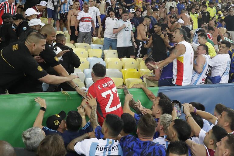 AMDEP3569. RÍO DE JANEIRO (BRASIL), 21/11/2023.- Emiliano Martínez (c) portero de Argentina intenta controlar disturbios entre hinchas de Brasil y de Argentina hoy, en un partido de las eliminatorias para la Copa Mundo de Fútbol de 2026 entre Brasil y Argentina en el estadio Maracaná en Río de Janeiro (Brasil). EFE/ Andre Coelho
