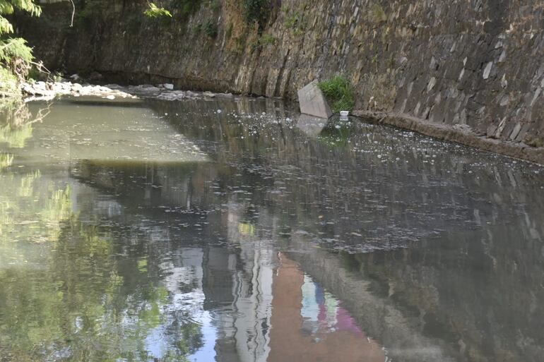 Sobre la superficie del arroyo se observan materiales fecales flotando.