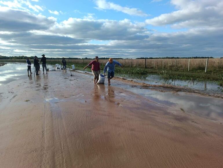  Pobladores de Tacuaras intentan arreglar como pueden uno de los caminos rurales. 