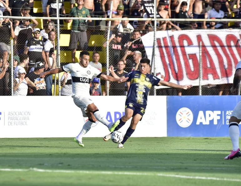 Fernando Cardozo (Olimpia) y Christian Martínez (Trinidense) pelean el balón.