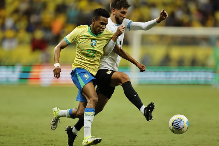 Estêvão Willian (i) de Brasil disputa el balón con Rodrigo Bentancur de Uruguay este martes, en un partido de las eliminatorias sudamericanas para el Mundial de 2026 entre Brasil y Uruguay, en el estadio Arena Fonte Nova en Salvador (Brasil).