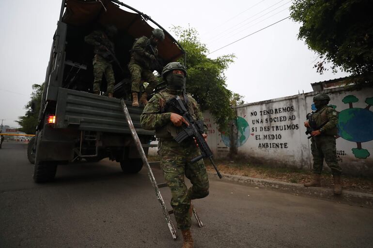 Militares se despliegan para custodiar el colegio electoral donde votará la candidata presidencial Luisa González, en Canuto, provincia de Manabi.