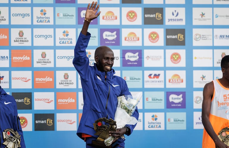 El atleta keniano Timothy Kiplagat posa en el podio tras ganar la prueba masculina de la 98 edición de la Carrera Internacional de San Silvestre hoy, en Sao Paulo (Brasil). La 98 San Silvestre brasileña estableció este año un nuevo récord de participantes con 35.000 inscritos.