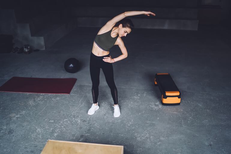 Una mujer realiza ejercicios de flexión lateral