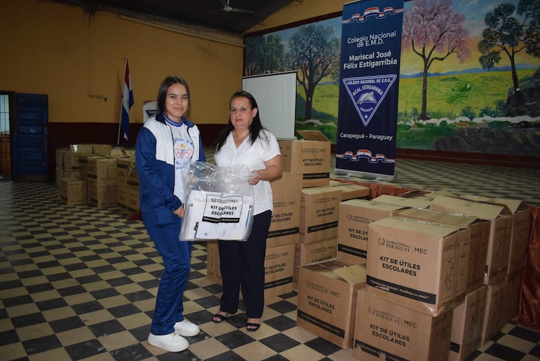 La directora Marta Ramírez hace entrega de un kit de útiles escolares a una alumna del colegio Mariscal José Félix Estigarribia.