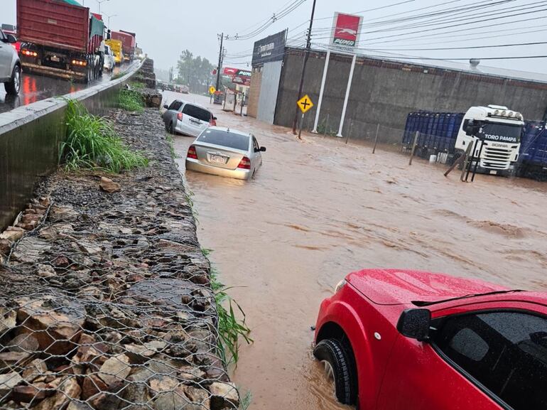 Colectora de la ruta PY03 quedó como río por la intensa lluvia  caída ayer y arrastró vehículos.