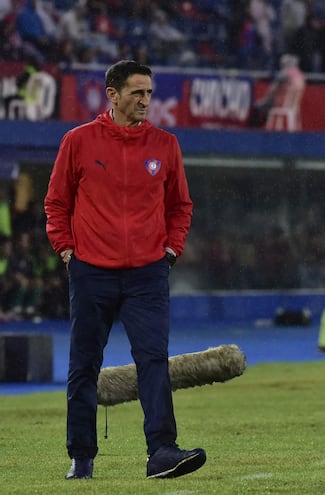 Manolo Jiménez,DT español de Cerro Porteño, camina con las manos en los bolsillos, mientras observa el juego.