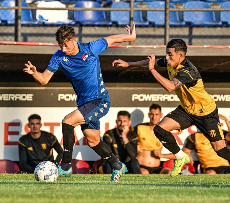 Uno de los albos nuevos, el pirayuense Jorge Darío Cáceres, se escapa del aurinegro Alcides Benítez con la pelota, en el amistoso de sábado en el estadio Arsenio Erico.