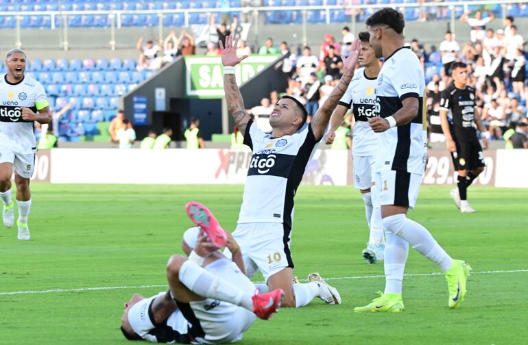 Brazos el alto de Derlis González (30 años) tras anotar su gol.  Se acercan Rodney Redes (24), Javier Domínguez (24) y Richard Ortiz (34). Hugo Fernández (27) se retuerce de dolor luego de recibir una dura infracción.