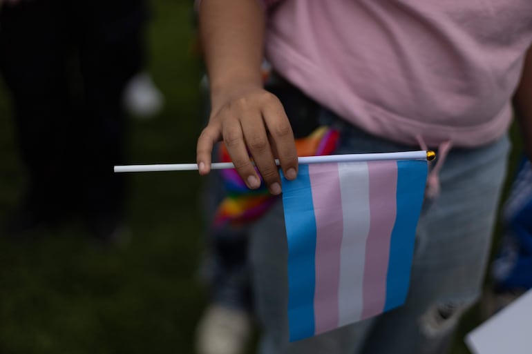 Persona sostiene una bandera del Orgullo.