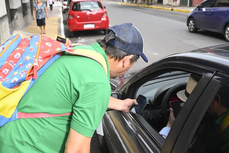 Ordenador de Parxin explica a conductor funcionamiento de app.