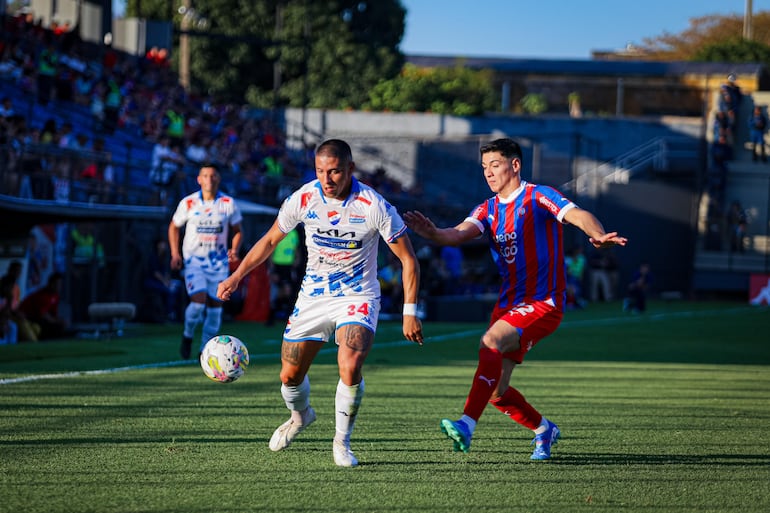 Jordan Santacruz, jugador de Nacional, y Derlis Rodríguez, futbolista de Cerro Porteño, pelean por el balón en un partido por la fecha 19 del torneo Clausura 2024 del fútbol paraguayo en el estadio Arsenio Erico, en Asunción, Paraguay.