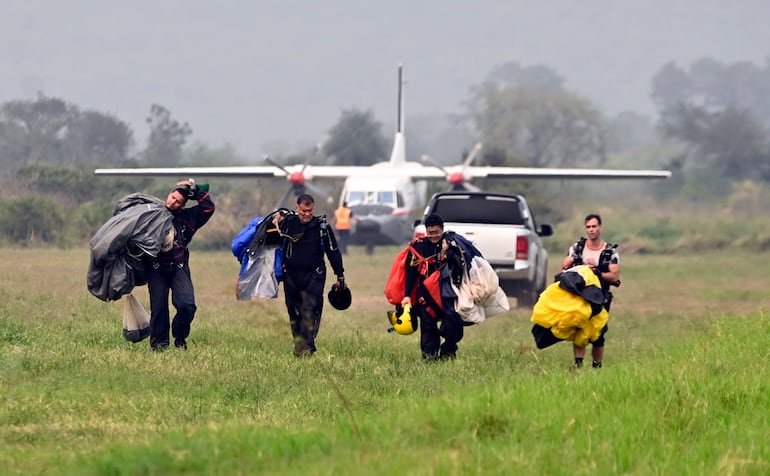 Momento en que el hijo de Cartes, Juampi (1º der.), regresa luego del salto realizado ayer desde C-212 de la Fuerza Aérea.