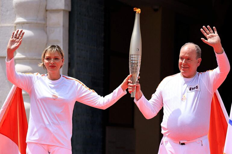 El príncipe Alberto de Mónaco y la princesa Charlene de Mónaco sostienen la antorcha de la Llama Olímpica durante una ceremonia de relevo en Mónaco, antes de los Juegos Olímpicos y Paralímpicos de París 2024.