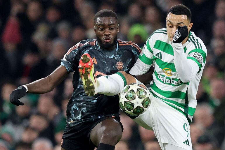 GLASGOW (United Kingdom), 12/02/2025.- Adam Idah (R) of Celtic in action against Dayot Upamecano of Bayern during the UEFA Champions League knockout phase play-offs 1st leg match between Celtic FC and FC Bayern Munich, in Glasgow, Britain, 12 February 2025. (Liga de Campeones, Reino Unido) EFE/EPA/ROBER PERRY
