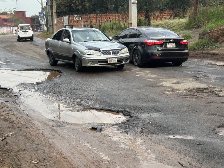 Los vehículos tienen que desviar constantemente los cráteres en la calle.