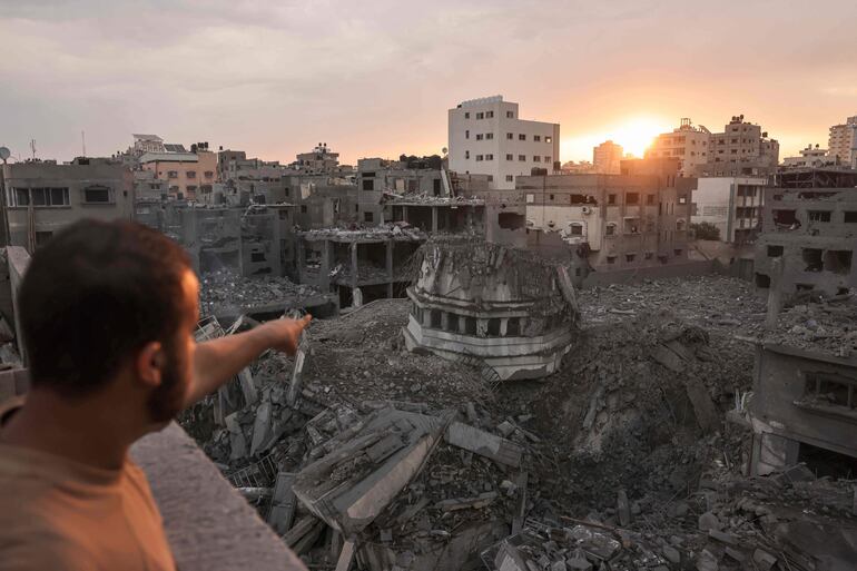 Un hombre señala la mezquita Ahmed Yassin, destruida por un bombardeo israelí sobre la Ciudad de Gaza, este lunes.