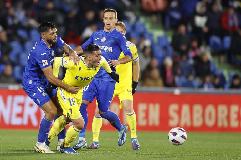 GETAFE (MADRID), 06/11/2023.- El delantero del Cádiz Sergio Guardiola (2i) cae agarrado por el paraguayo Omar Alderete (i), del Getafe, durante el partido de la jornada 12 de Liga de Primera División que Getafe CF y Cádiz CF diputan este lunes en el Coliseum de Getafe. EFE/Javier Lizón
