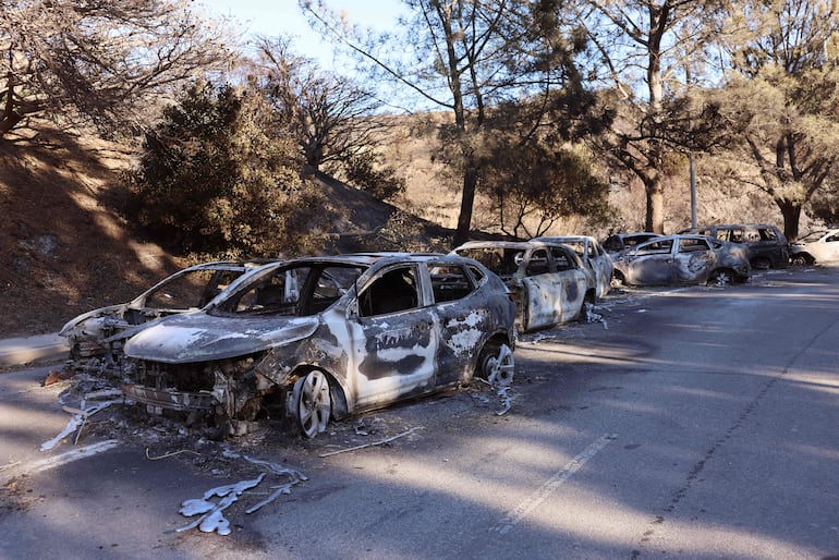 Vehículos quemados se alinean en una calle mientras el incendio Palisades sigue creciendo en Los Ángeles, California.