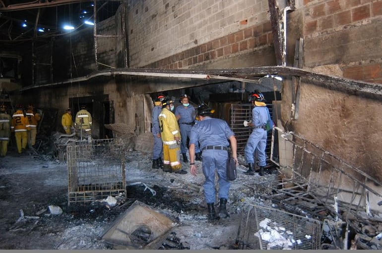 Bomberos recorren el Ycua Bolaños durante el siniestro el 1 de agosto del 2004, entre escombros y cenizas.