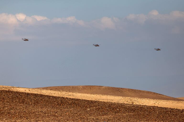 Helicópteros de transporte militar pesado de la Fuerza Aérea israelí sobrevuelan el desierto del sur del Néguev. (Photo by AHMAD GHARABLI / AFP)