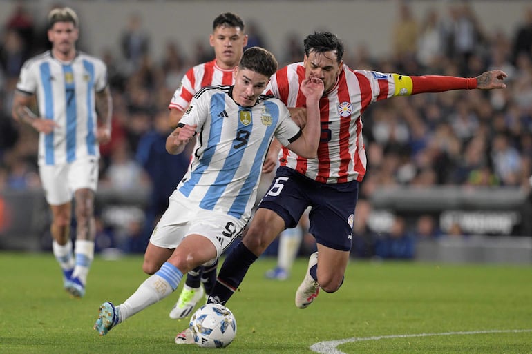 El delantero argentino Julián Álvarez (i) y el defensor paraguayo Gustavo Gómez luchan por el balón durante el partido de fútbol de clasificación sudamericano para la Copa Mundial de la FIFA 2026 entre Argentina y Paraguay en el estadio Mas Monumental de Buenos Aires, el 12 de octubre de 2023.