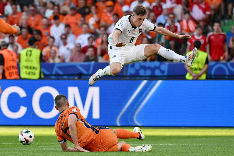 TOPSHOT - Austria's midfielder #08 Alexander Prass jumps over Netherlands' defender #06 Stefan de Vrij during the UEFA Euro 2024 Group D football match between the Netherlands and Austria at the Olympiastadion in Berlin on June 25, 2024. (Photo by Christophe SIMON / AFP)