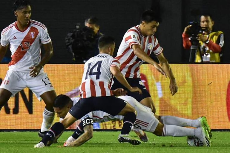 Andrés Cubas (i) de Paraguay disputa el balón con Paolo Guerrero (abajo) de Perú hoy, en un partido de las Eliminatorias Sudamericanas para la Copa Mundial de Fútbol 2026 entre Paraguay y Perú en el estadio Antonio Aranda en Ciudad del Este (Paraguay). 
