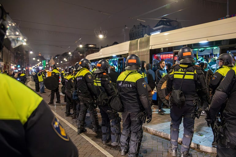 Agentes de policía establecen un cordón de seguridad alrededor de un autobús después del partido de fútbol entre Ajax y Maccabi Tel Aviv, en Ámsterdam, Países Bajos, en la madrugada del 8 de noviembre de 2024.