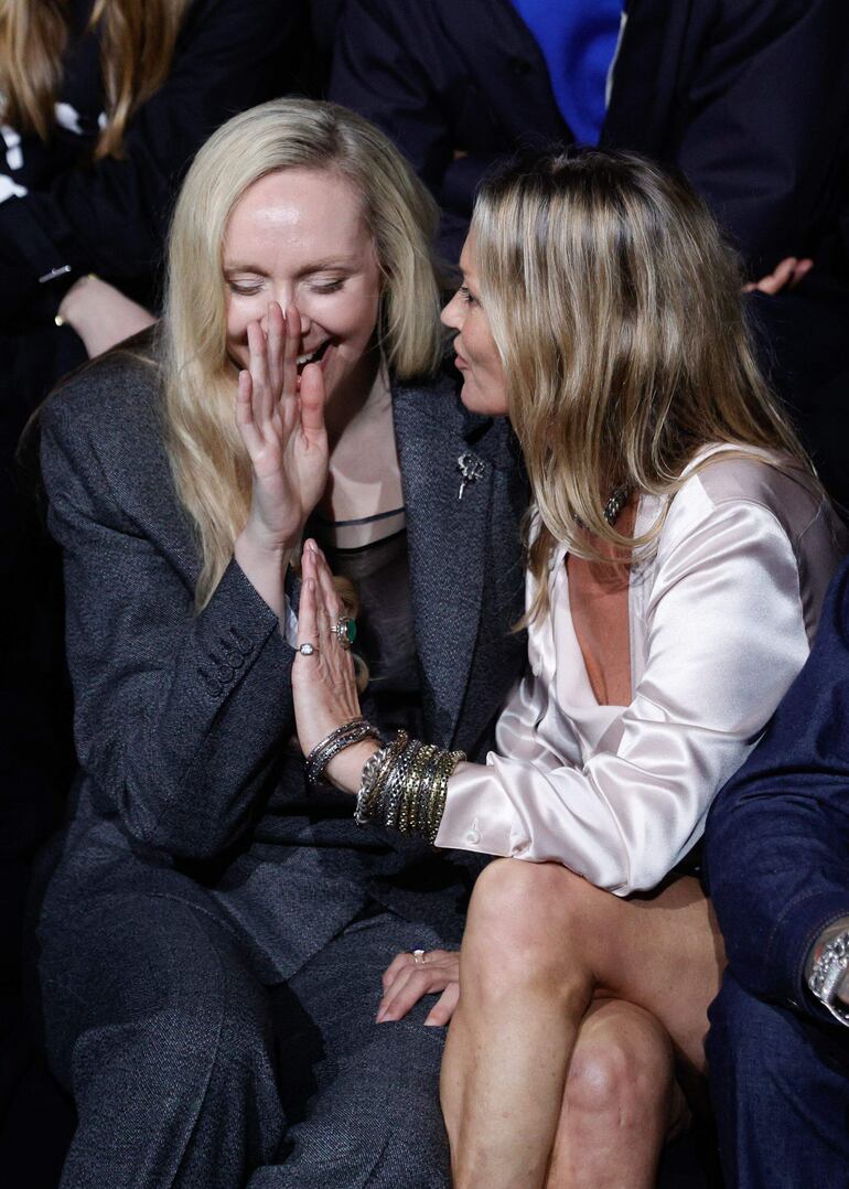 La actriz británica Gwendoline Christie compartiendo un momento alegre con la modelo británica Kate Mos sentadas en primera fila durante la presentación de la colección Dior. (GEOFFROY VAN DER HASSELT / AFP)