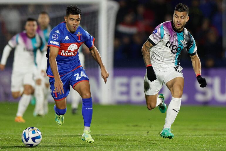 El paraguayo Héctor Villalba (d), futbolista de Libertad, pelea por el balón con el argentino Martin Garay, jugador de Tigre, en el partido por los playoffs de la Copa Sudamericana en el estadio José Dellagiovanna, en Victoria, Buenos Aires.