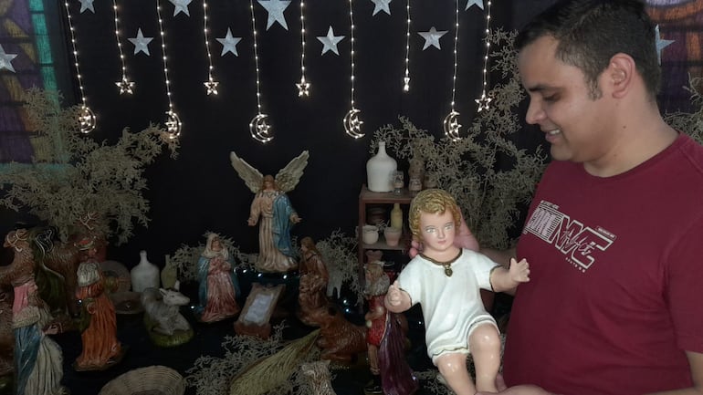 El sacerdote redentorista Juan Núñez, sostiene en sus manos la imagen del niño Jesús que será puesto en el pesebre en la noche buena. Archivo 2022.