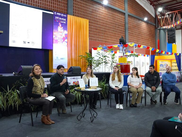 Nadia Czeraniuk, rectora de la UNAE, Eder Acuña, decano de la Facultad de Ciencias, Arte y Tecnologías, y estudiantes de la carrera de Diseño Gráfico durante la presentación del libro.