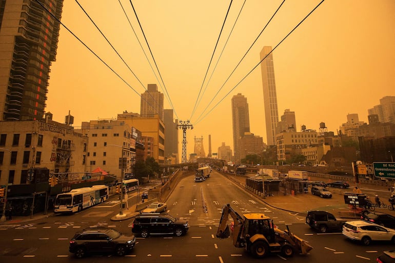 El tráfico se mueve cerca del puente Ed Koch Queensboro mientras el humo de los incendios forestales canadienses arroja una neblina sobre el área el 7 de junio de 2023 en la ciudad de Nueva York.