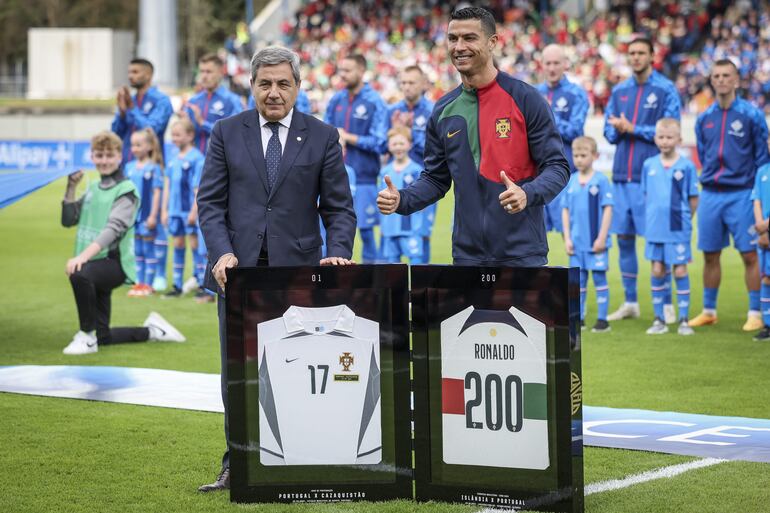 Reykjavik (Islândia), 20/06/2023.- Portugal´s Cristiano Ronaldo (R) receives a plaque from the Guiness Book of World Records for his 200th international appearance for the Portuguese national soccer team before the UEFA Euro 2024 qualifying soccer match between Iceland and Portugal, at Laugardalsvollur Stadium, in Reykjavik, Iceland, 20 June 2023. (Islandia) EFE/EPA/JOSE SENA GOULAO
