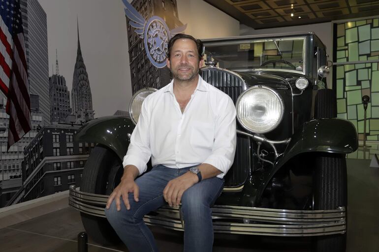 Gerardo Jean Carrasco posa junto a un automóvil Chrysler 1929, serie 75 Custom Convertible Sedán. 