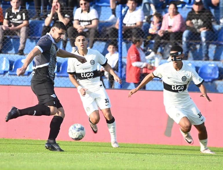 Diego Viera rechaza el balón ante la mirada de Hugo Benítez, de Olimpia