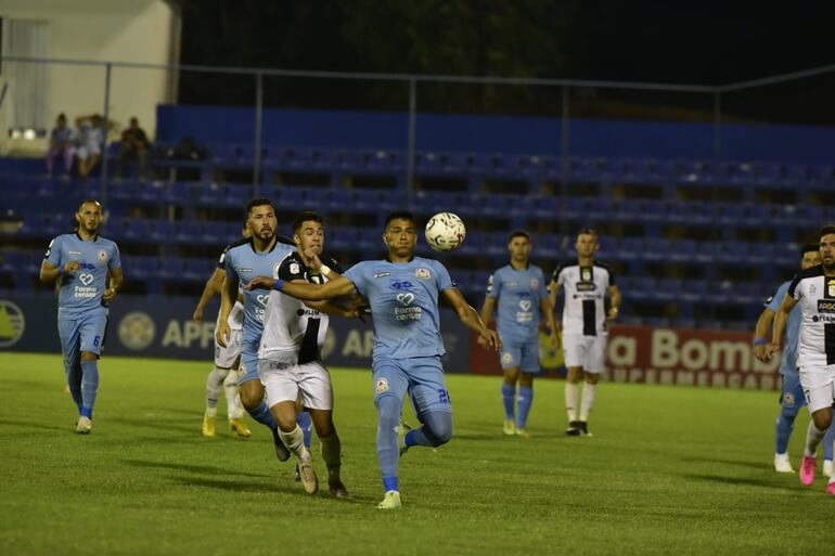 Iván Almeida, jugador de Tacuary, pelea el balón con Pablo Adorno, de Resistencia.