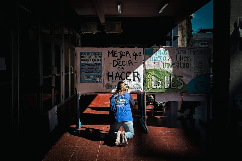 Una mujer pintando un cartel en la Facultad de Ciencias Sociales de la UBA, en Buenos Aires (Argentina). El Senado argentino aprobó en la madrugada de este viernes el proyecto de ley de financiación de la educación universitaria, en medio de las protestas de los docentes y personal del sector y bajo la amenaza de veto del presidente, Javier Milei.